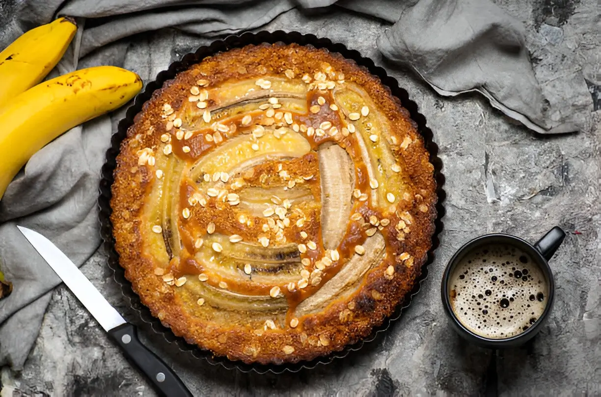 Image of a beautifully sliced almond nut cake on a plate, showcasing its moist texture and topped with a light dusting of powdered sugar.