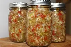 A vibrant bowl of homemade chow chow featuring colorful chopped cabbage, carrots, and bell peppers in a tangy pickling solution.