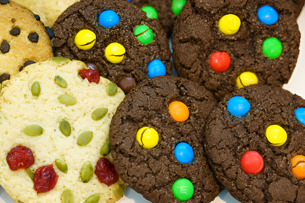 Ingredients for chocolate chip cookies laid out on a kitchen counter, including flour, sugar, butter, and chocolate chips.