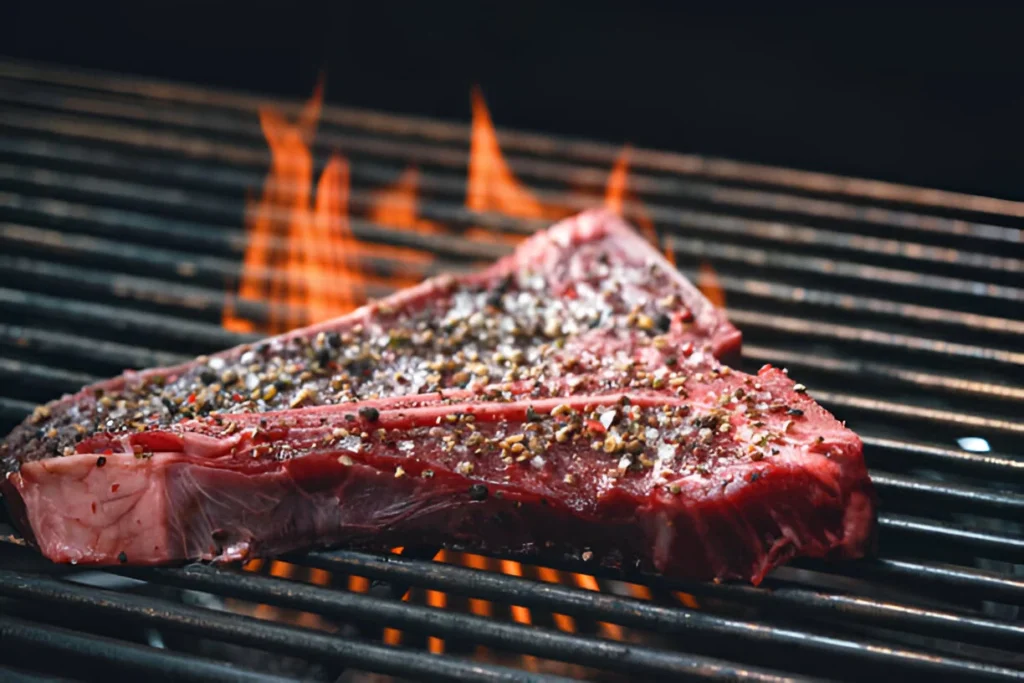 Image of succulent boneless beef ribs garnished with fresh herbs, served with coleslaw and baked beans on a rustic wooden platter.