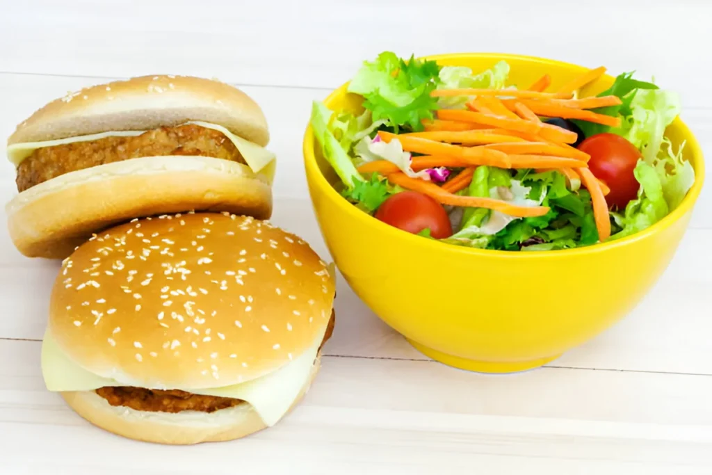 A colorful burger bowl featuring ground beef, fresh lettuce, tomatoes, cheese, and a variety of toppings served in a bowl.