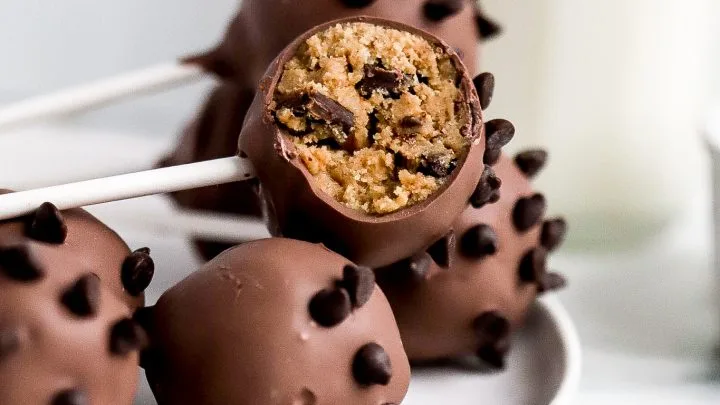 Homemade Starbucks-style cake pops decorated with colorful sprinkles and chocolate drizzle on a cake pop stand.