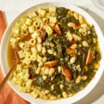 A bowl of vibrant swamp soup garnished with fresh herbs and accompanied by crusty bread.